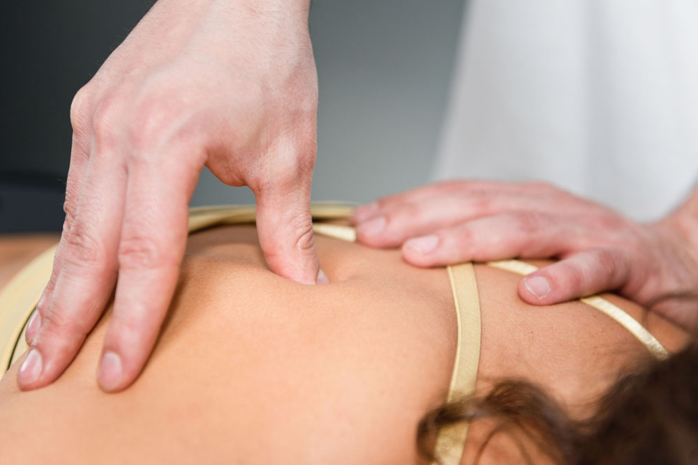 woman receiving a massage for her upper back pain